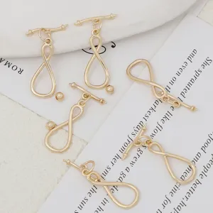 Primer plano detallado de accesorios de joyería DIY chapados en oro, cierres OT y anillas.