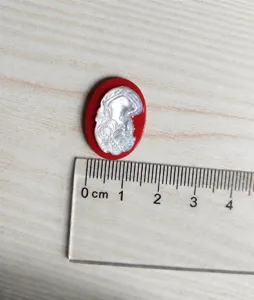 Natural mother-of-pearl shell cameo detail, oval red base pendant carving closeup.