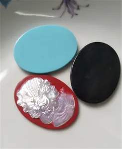 Detail view of natural shell cameo cabochon pendant and blank oval DIY jewelry making accessories.