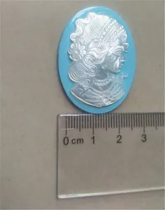 Close-up detail of a blue shell cameo pendant featuring a classical lady relief carving.