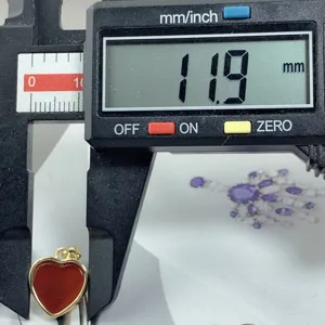Red agate heart pendant detail view, measuring approx 11.9mm with electronic caliper for jewelry display