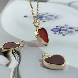 Exquisite red carnelian heart pendant detail, minimalist gold-rimmed fashion jewelry.