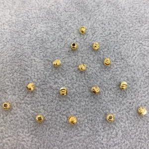 Detail shot of 4mm twisted gold plated spacer beads for DIY jewelry making and crafting.