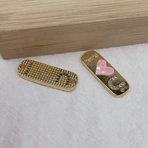 Goldfarbene DIY Schmuck Metall Anhänger Detail, rosa Herz und Strass Buchstaben Charm.