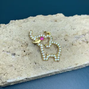 Close-up of gold-plated elephant pendant detailed with clear rhinestones and pink crystal eye.