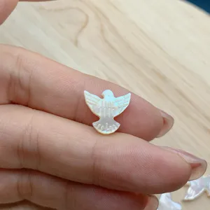 Primer plano de cuenta de concha de paloma de nácar blanco, detalle accesorio joyería DIY.