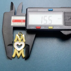 MOM letter heart pendant detail shot showing precise size measurement with a digital caliper.