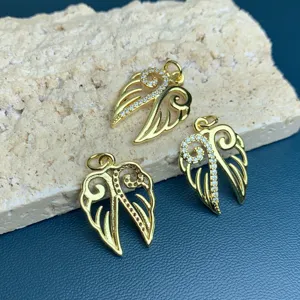 Close-up detail of gold rhinestone wing charm pendants for DIY jewelry making accessories.