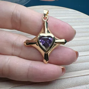 Detailansicht eines vergoldeten geometrischen Anhängers mit lila Herz Zirkonia Stein.