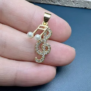 Close-up detail of gold treble clef pendant, sparkling micro-pave cubic zirconia and pearls.
