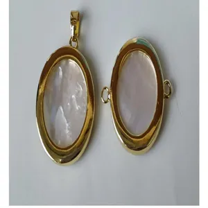 Close-up details of oval white mother-of-pearl gold plated DIY jewelry pendant and connector.