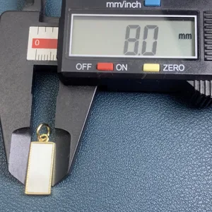 Mesure de détail et gros plan des accessoires de pendentif nacré rectangulaire de fin.