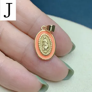 Gros plan sur le pendentif ovale en émail Guadalupe, beau cadre doré et bordure orange.