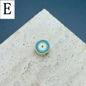 Gros plan détaillé sur la perle ronde émaillée œil maléfique, accessoire bijou DIY doré.