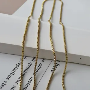Nahaufnahme Detailaufnahme einer filigranen vergoldeten Box-Kette, minimalistischer Schmuck.