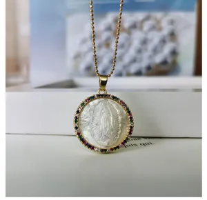 Mother-of-pearl virgin mary pendant necklace detail showing colorful cubic zirconia border.