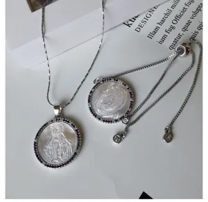 Detailed close-up shot of white mother of pearl necklace and bracelet with colorful zirconia.