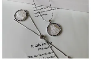 White mother of pearl necklace bracelet set with colorful zircon and religious pendant detail.