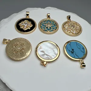 Set di ciondoli rotondi con madreperla, turchese e zircone in elegante finitura dorata.