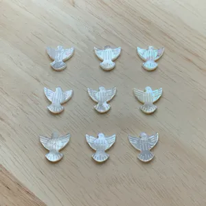 Detalle de cuentas de nácar blanco natural con forma de paloma para hacer joyería DIY.
