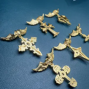 Gros plan de pendentifs croix ailés en zircon doré, détail élégant de bijoux style hip-hop.