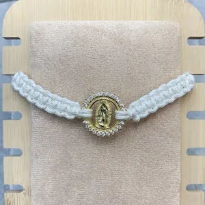 Adjustable braided rope bracelet featuring a gold-toned Guadalupe pendant with sparkling zirconia.