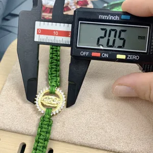 Adjustable green braided rope bracelet featuring a gold Guadalupe pendant with sparkling cubic zirconia.