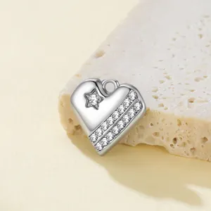 Primer plano detallado del colgante de corazón de plata con cristales y estrella.