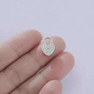 Vista detallada del colgante de candado en corazón, pavé de circonitas brillantes y metal.