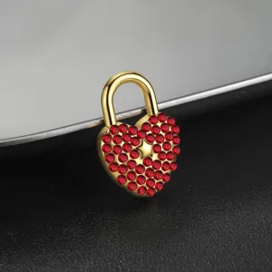 Primer plano detalle de un colgante candado corazón de acero con cristales rojos.