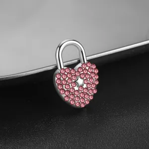 Primer plano detallado de un candado de corazon de acero inoxidable con cristales rosas.
