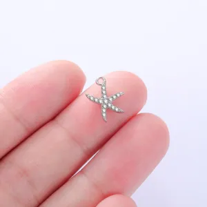 Detailed close-up shot of a sparkly rhinestone starfish pendant displayed on clean fingertips.