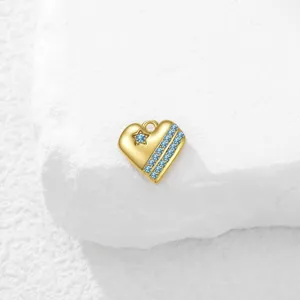 Precioso colgante de corazón en acero inoxidable bañado en oro con circonitas azules.