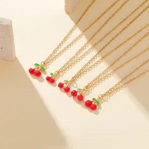 Detailed close-up view of elegant gold-tone necklaces featuring cute red enamel cherry charms.