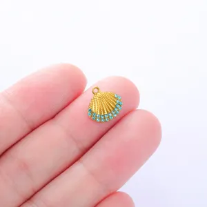 Close-up detail of a gold-tone seashell pendant adorned with sparkling blue rhinestones.
