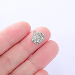 Close-up detail of a silver tone rhinestone shell pendant for DIY jewelry making.