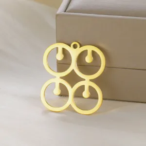 Close-up detail of a gold metallic African ethnic symbol pendant made of stainless steel material.