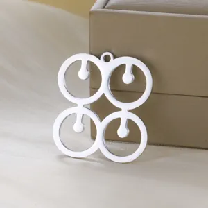 Stainless steel African geometric symbol pendant detail showing fine metallic texture.