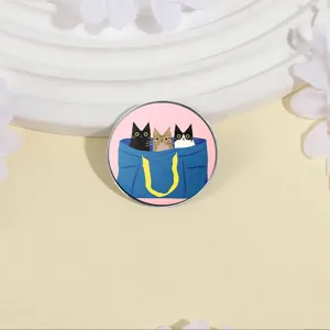 Detail view of cute three cats metal brooch pin, charming cat illustration badge accessory.