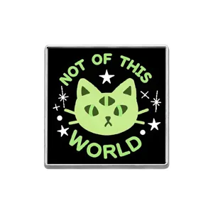 Gros plan détaillé du badge émaillé chat vert à trois yeux avec design d'étoiles.