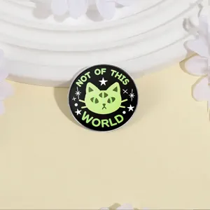 Gros plan détail d'une broche badge en métal chat extraterrestre à trois yeux créative.