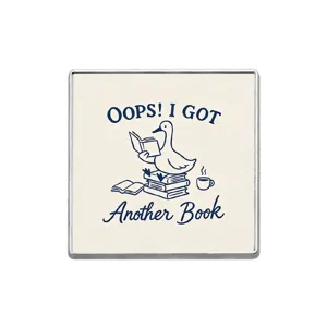 Close-up detail of the cute reading duck metal badge featuring lovely book lover slogan text.