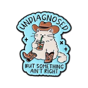 Cute cat enamel pin detail showing a funny cowboy feline drinking iced coffee with boots.