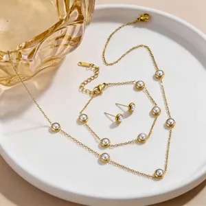 Detailed close-up shot of elegant gold stainless steel pearl necklace and bracelet jewelry.