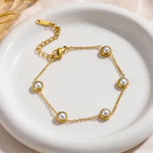 Close-up detail of the elegant gold-plated pearl station bracelet, showing delicate chain links.