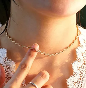Detail view of wavy gold plated stainless steel chain necklace, elegant and stylish design.