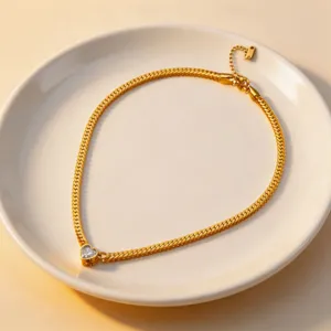 Detail view of the gold titanium steel heart zircon necklace displayed on a white plate.
