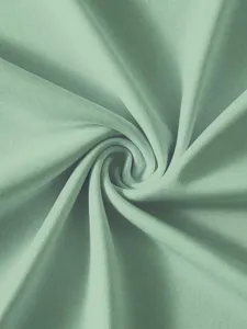 Primo piano dettagliato della morbida trama in tessuto verde salvia, con trama fine e drappeggio.