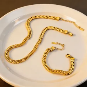 Gold titanium steel herringbone chain necklace bracelet detail view, elegant jewelry set.