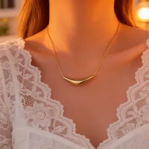 Elegant gold-plated curved pendant necklace, modern geometric hollow design, delicate detail shot.